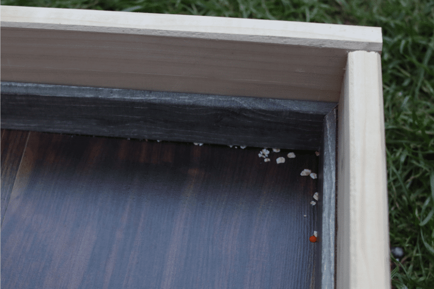 Немного Овсяных хлопьев остаются в углах во время испытания на всасывание овсяных хлопьев на ламинате.